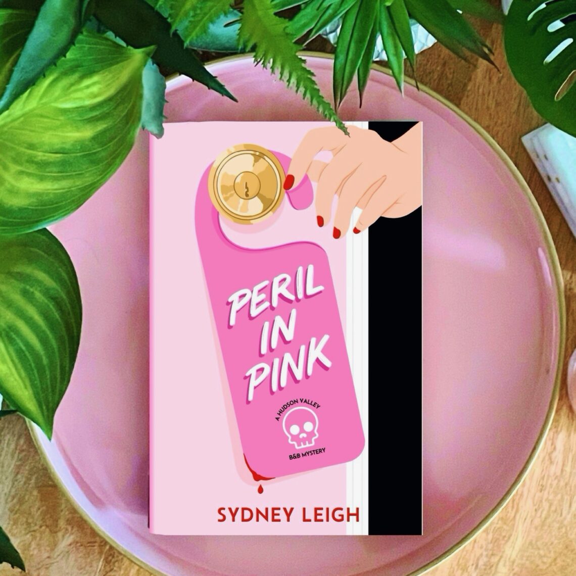 Peril in Pink is the first in a debut cozy mystery series by Sydney Leigh, featuring two friends who open a bed and breakfast that is decked out in pink